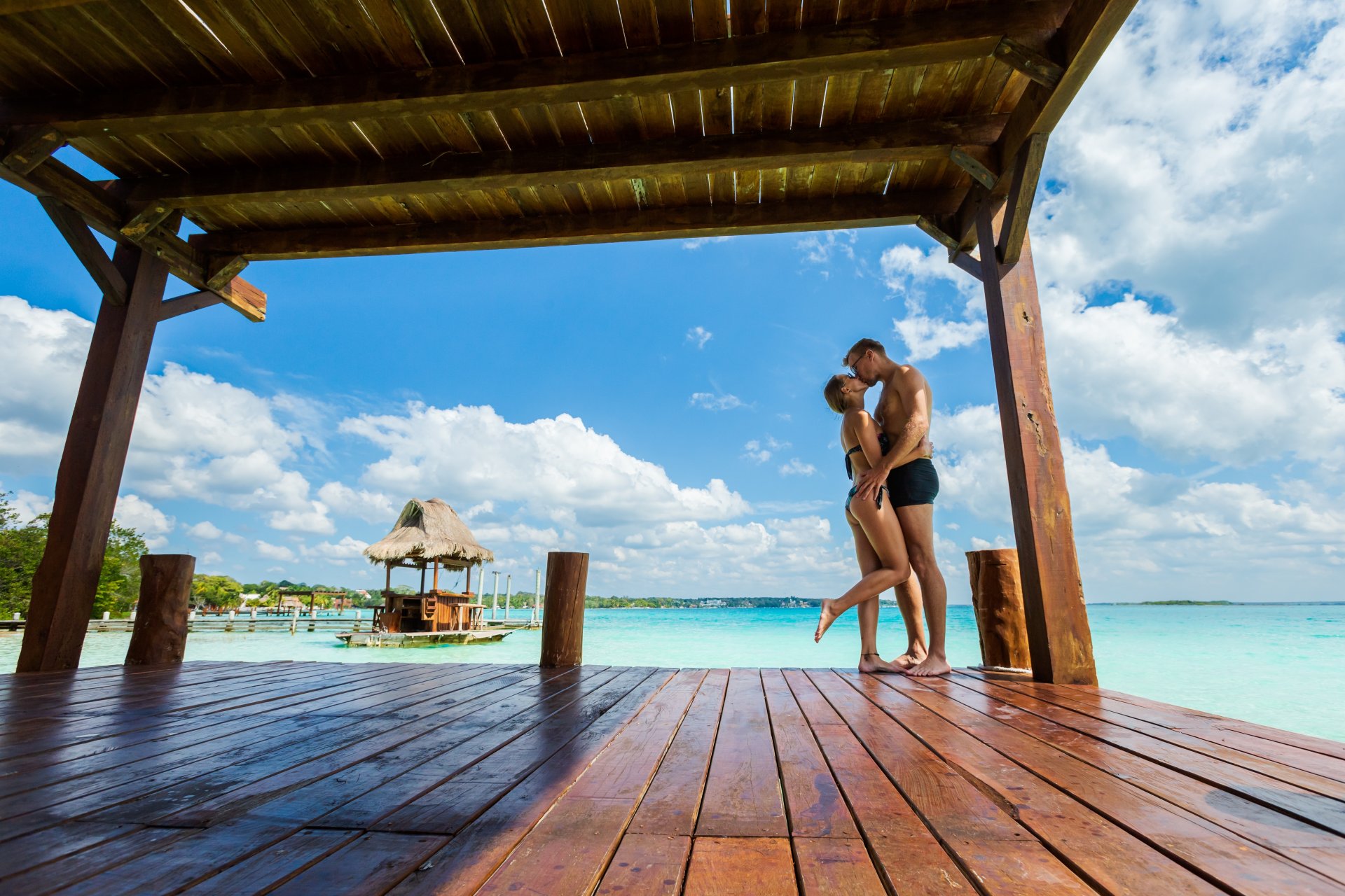 siluetă a unui cuplu sărutându-se lângă un palmier pe o plajă în Riviera Maya