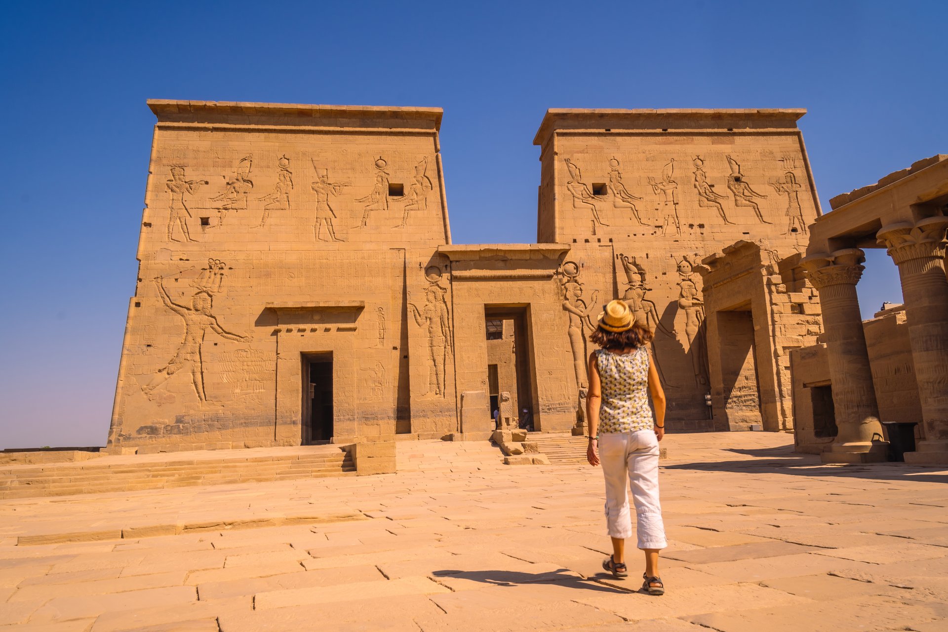 turista tanara viziteaza templul philae vazut de pe raul nil in aswan egipt