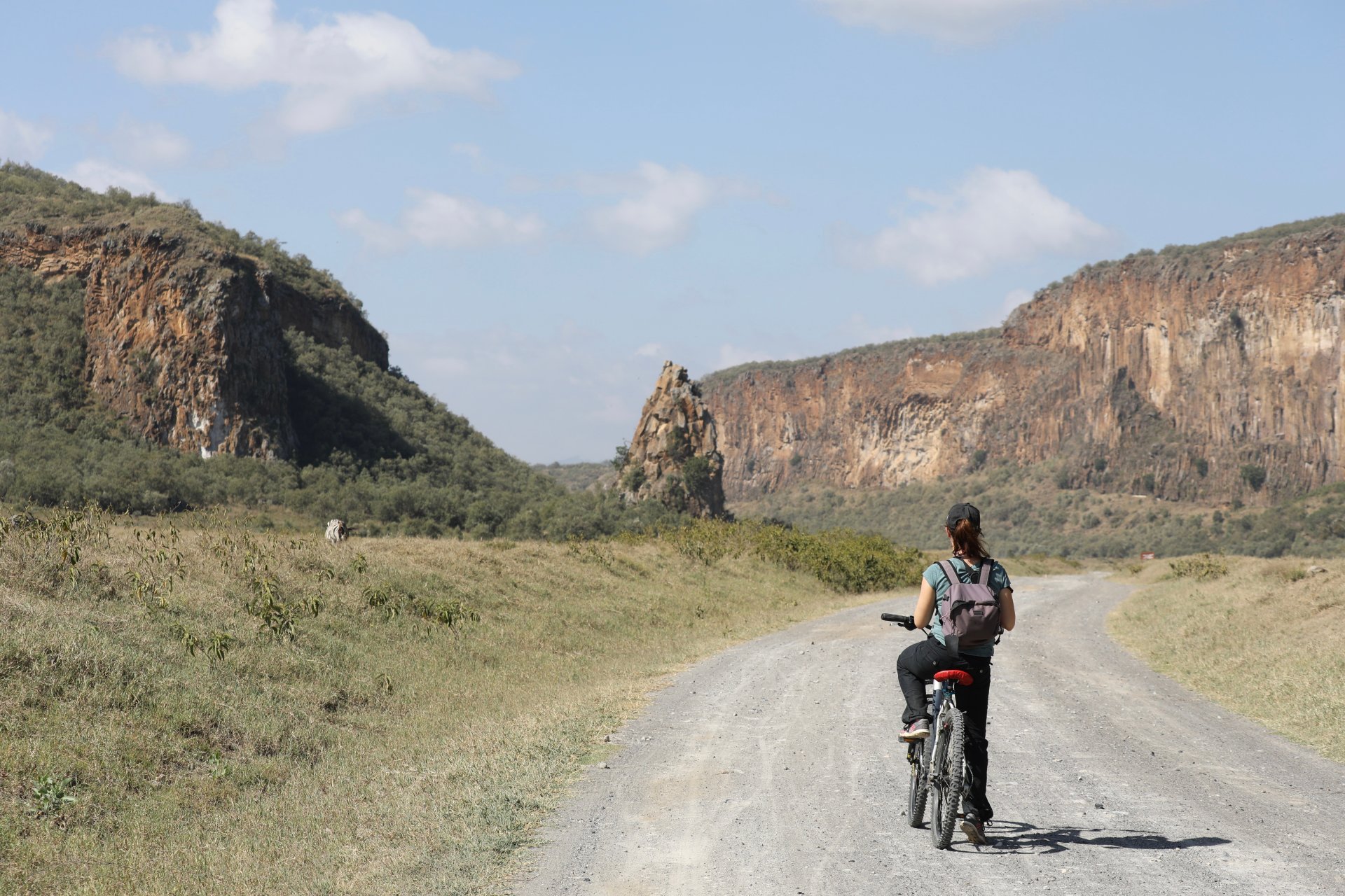 turist merge cu bicicleta in parcul national hells gate din kenya