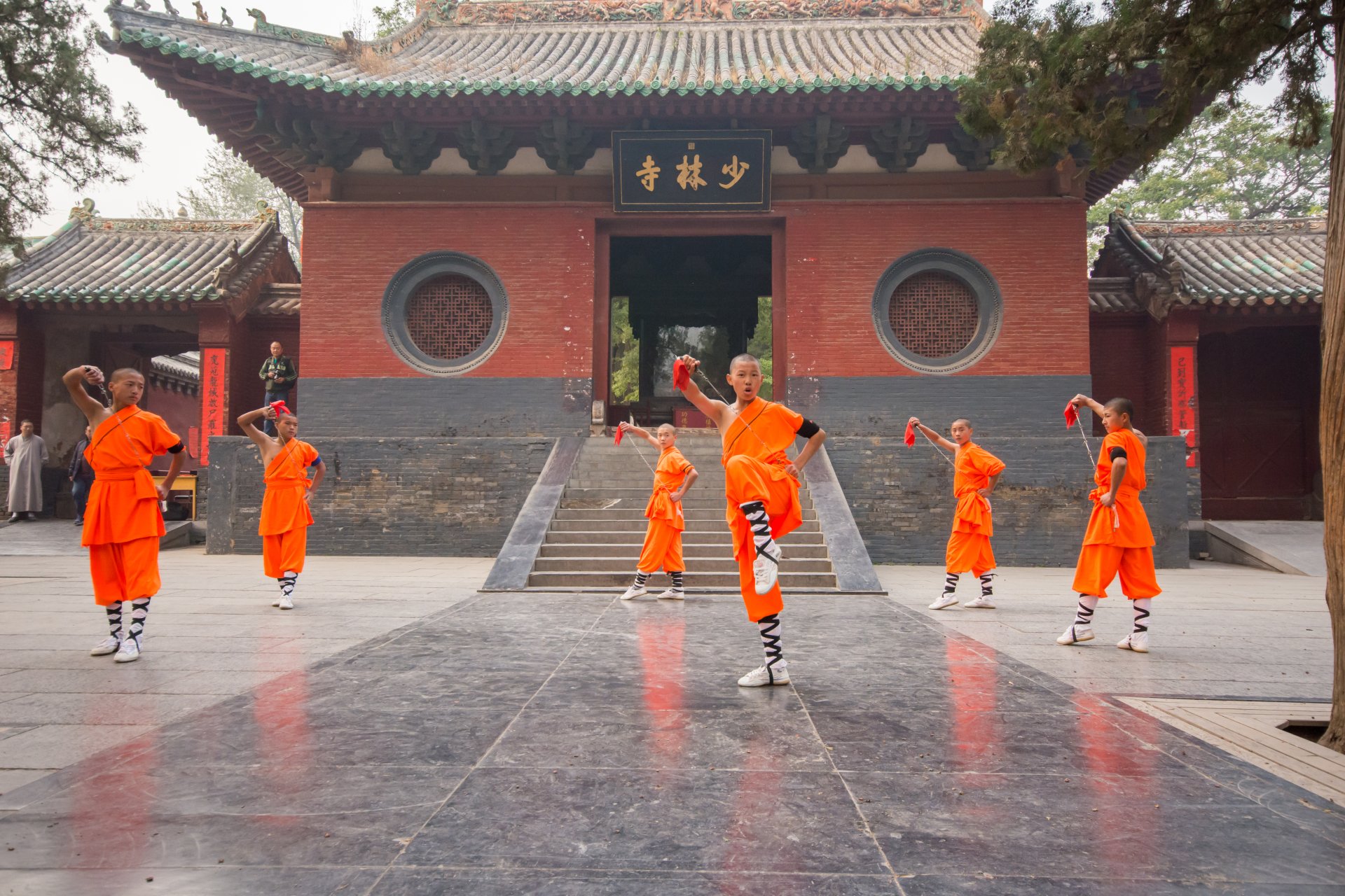 Grup de calugari si practicanti Shaolin sustin o demonstratie de kung fu in curtea Templului Shaolin din Dengfeng, provincia Henan, in fata turistilor.