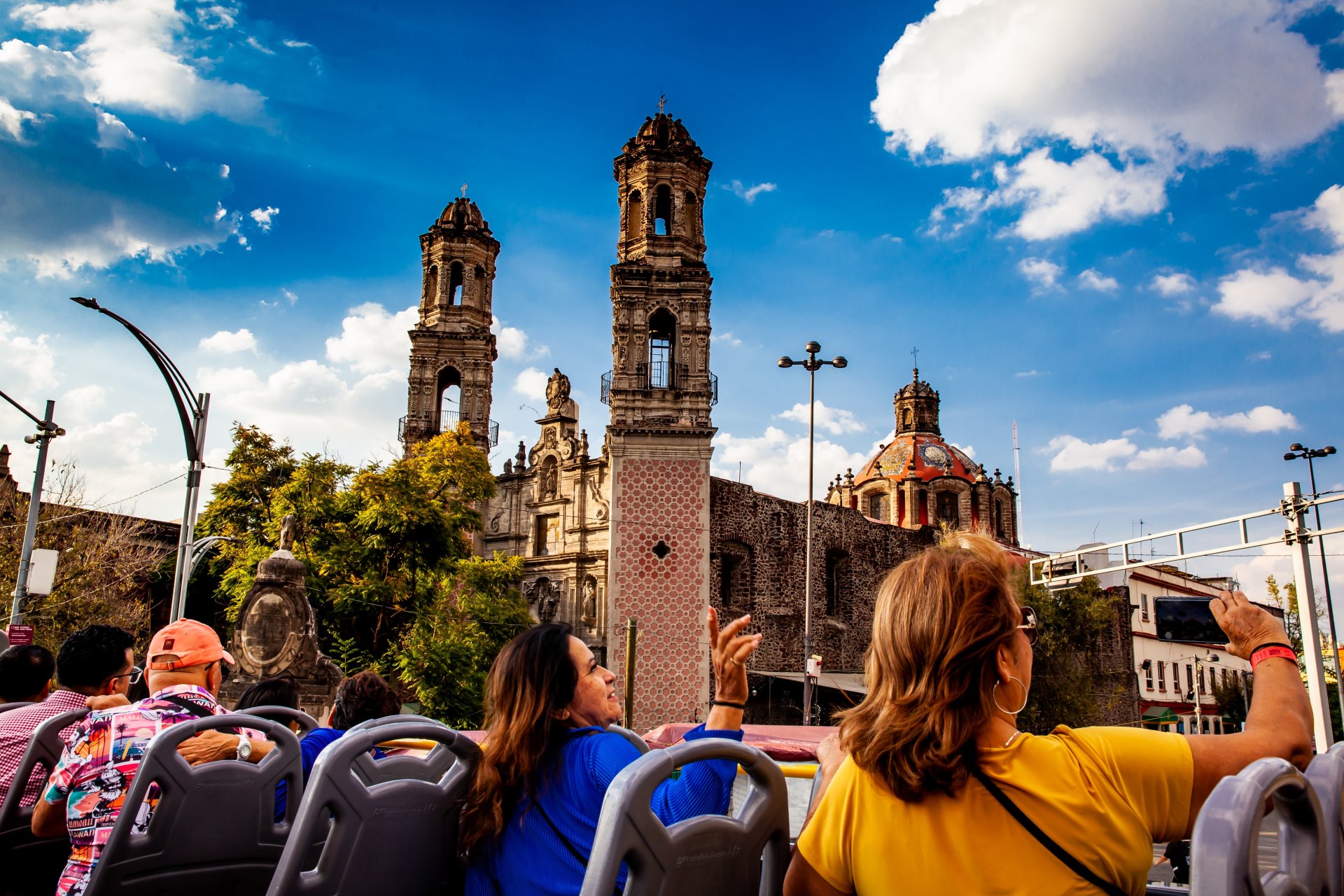 Un grup de oameni exploreaza centrul orasului Mexico City cu autobuzul turistic