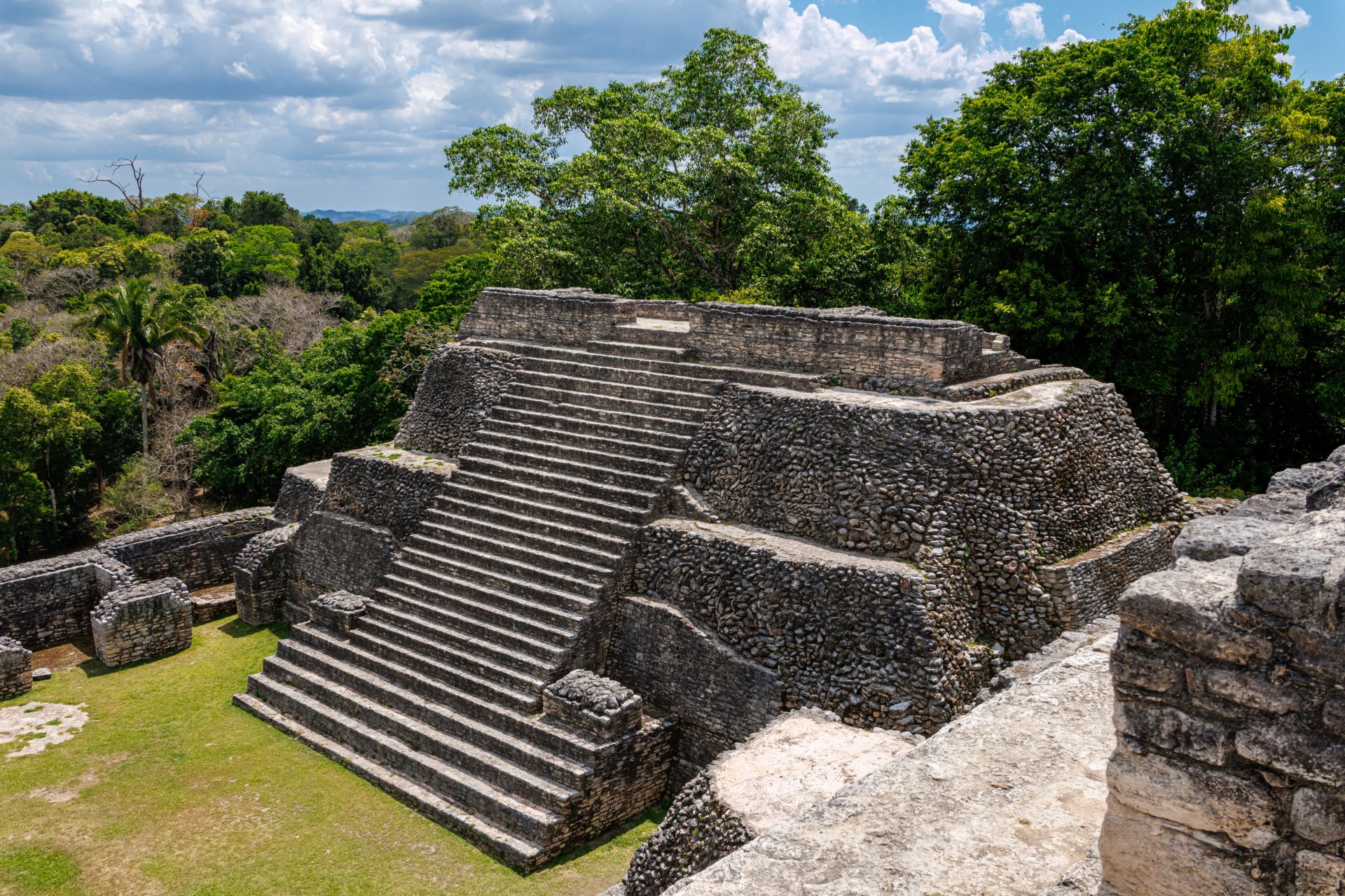 Vedere panoramică a sitului arheologic mayaș Caracol, Belize, cu piramide impunătoare și platforme ascunse printre copacii junglei tropicale