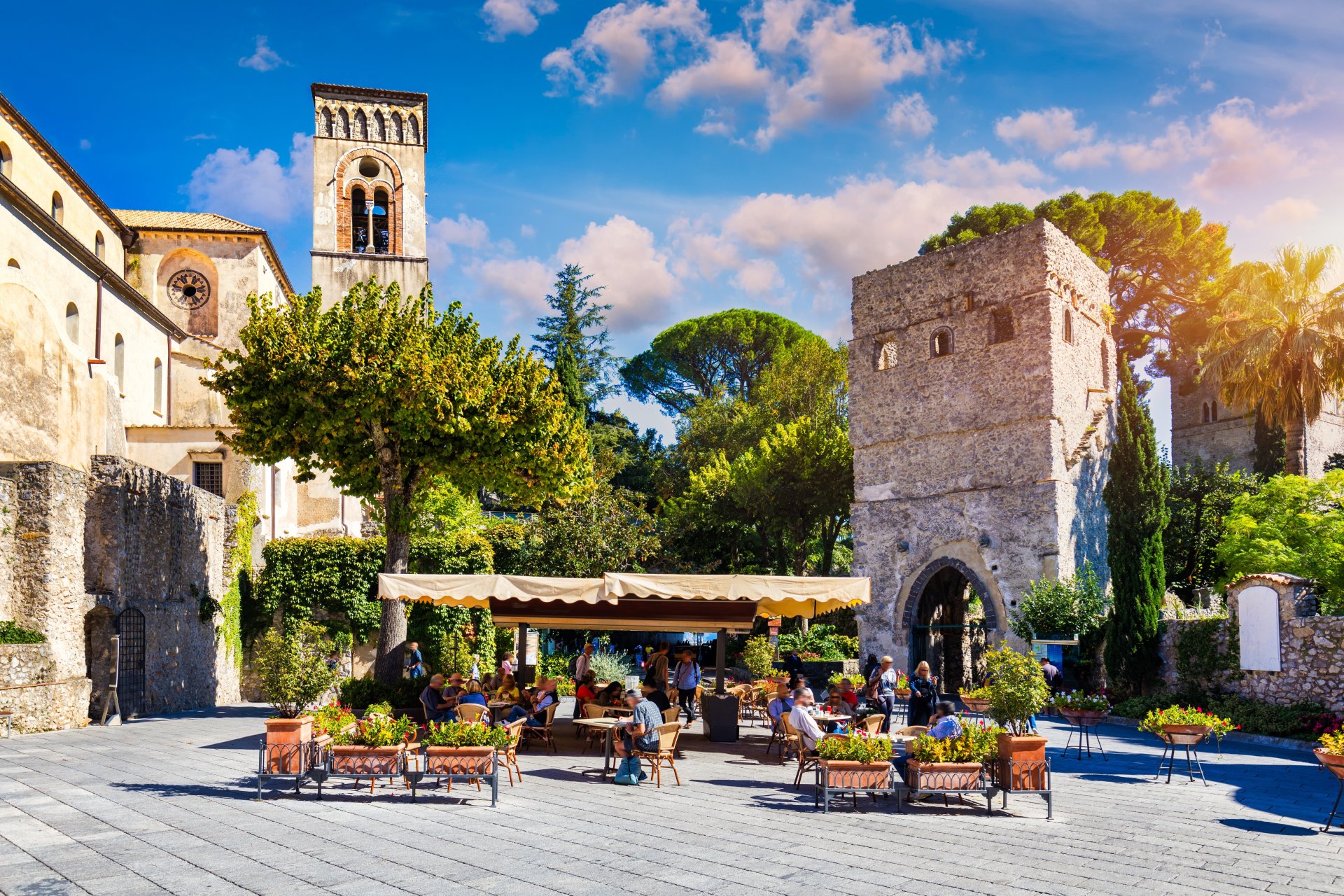 Panorama asupra orasului Ravello de pe Coasta Amalfitana, cu case colorate asezate pe versant, vegetatie mediteraneana si Marea Tireniana in fundal.