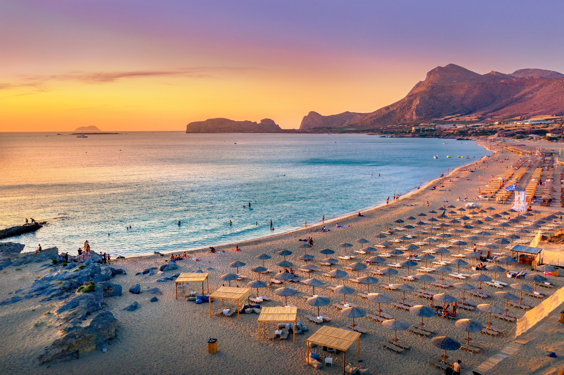 Vedere panoramica asupra plajei Falasarna din vestul insulei Creta, cu nisip auriu, apa turcoaz limpede si tarm intins scaldat de soarele mediteranean.