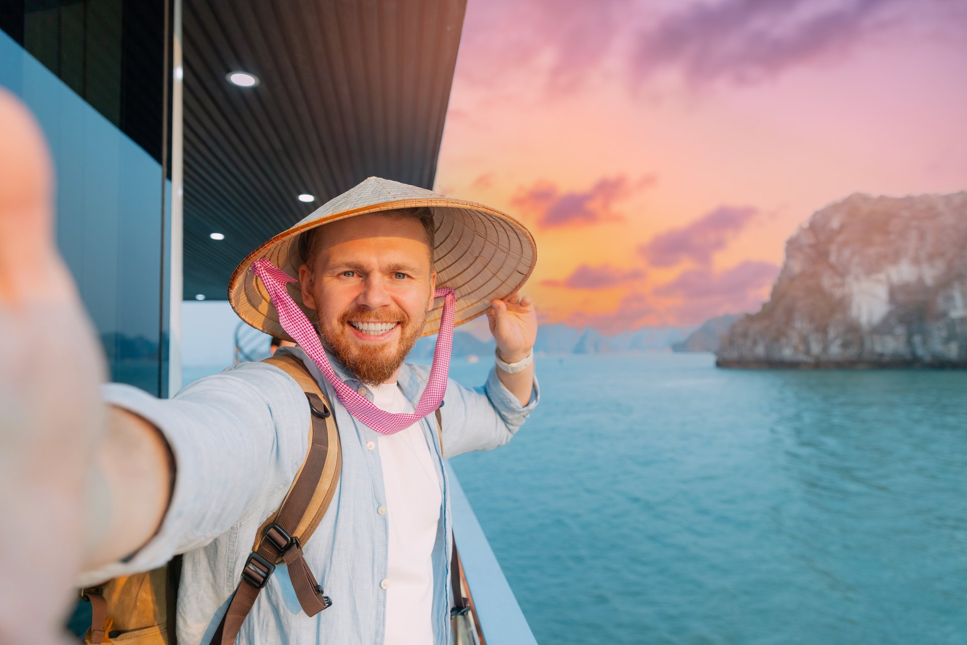 Turist caucazian zambitor care se bucura de apus de soare pitoresc in Halong Bay Vietnam