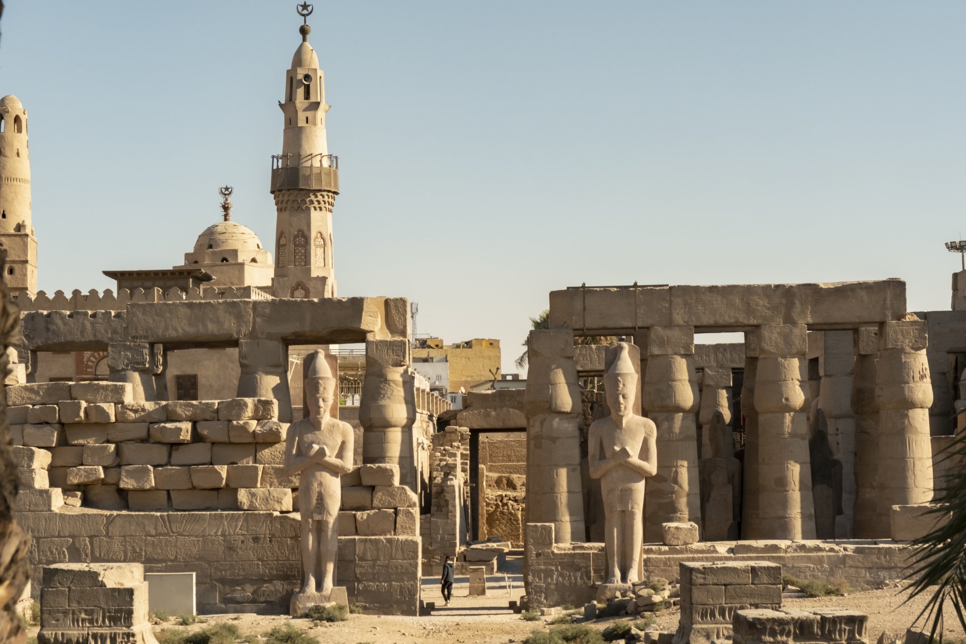 ruine antice din luxor cu statui si temple vizitate in timpul zilei sub un cer senin in egipt