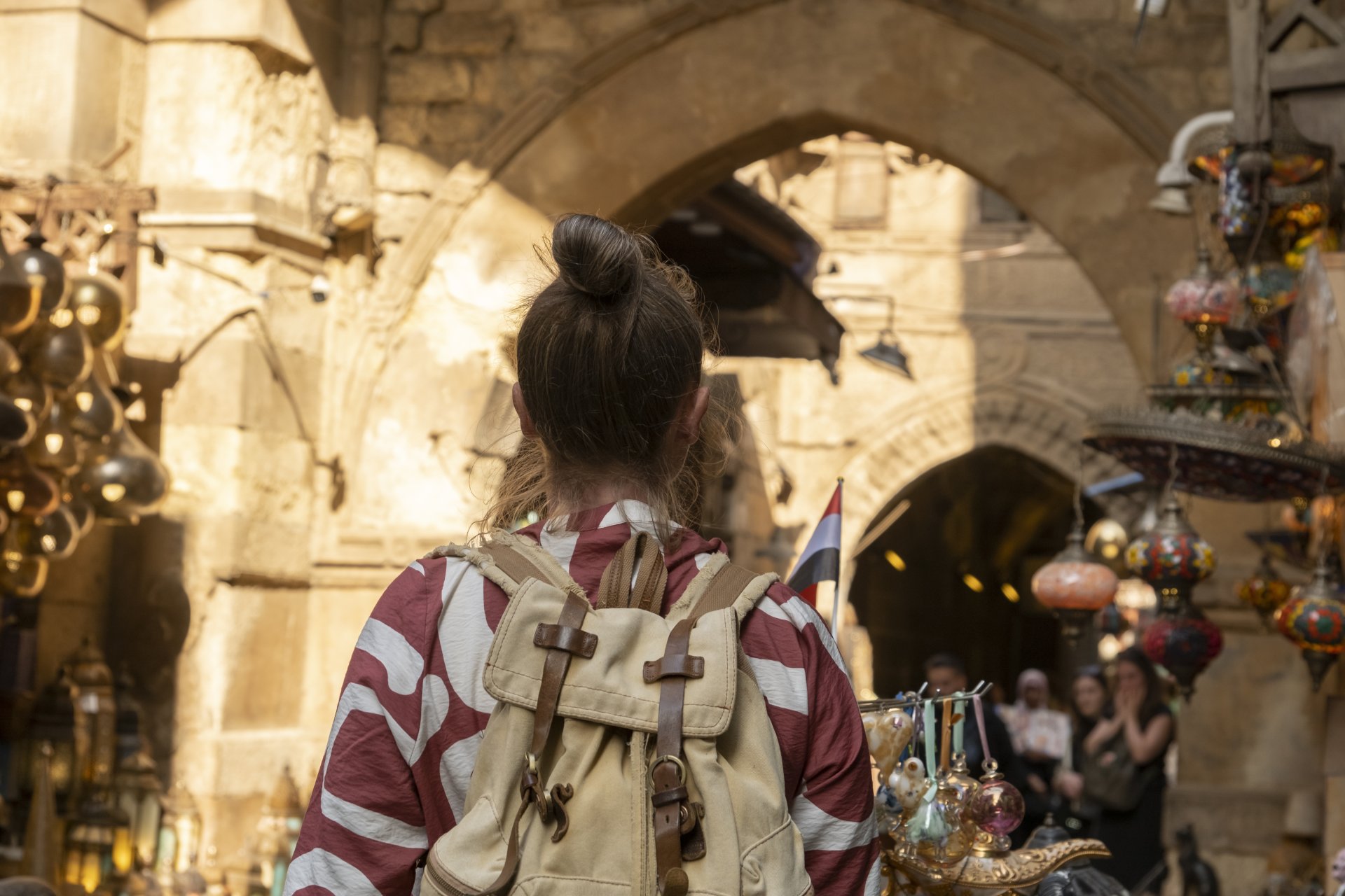 turist care se plimba printr-un bazar traditional din egipt printre tarabe si magazine intr-o zi insorita