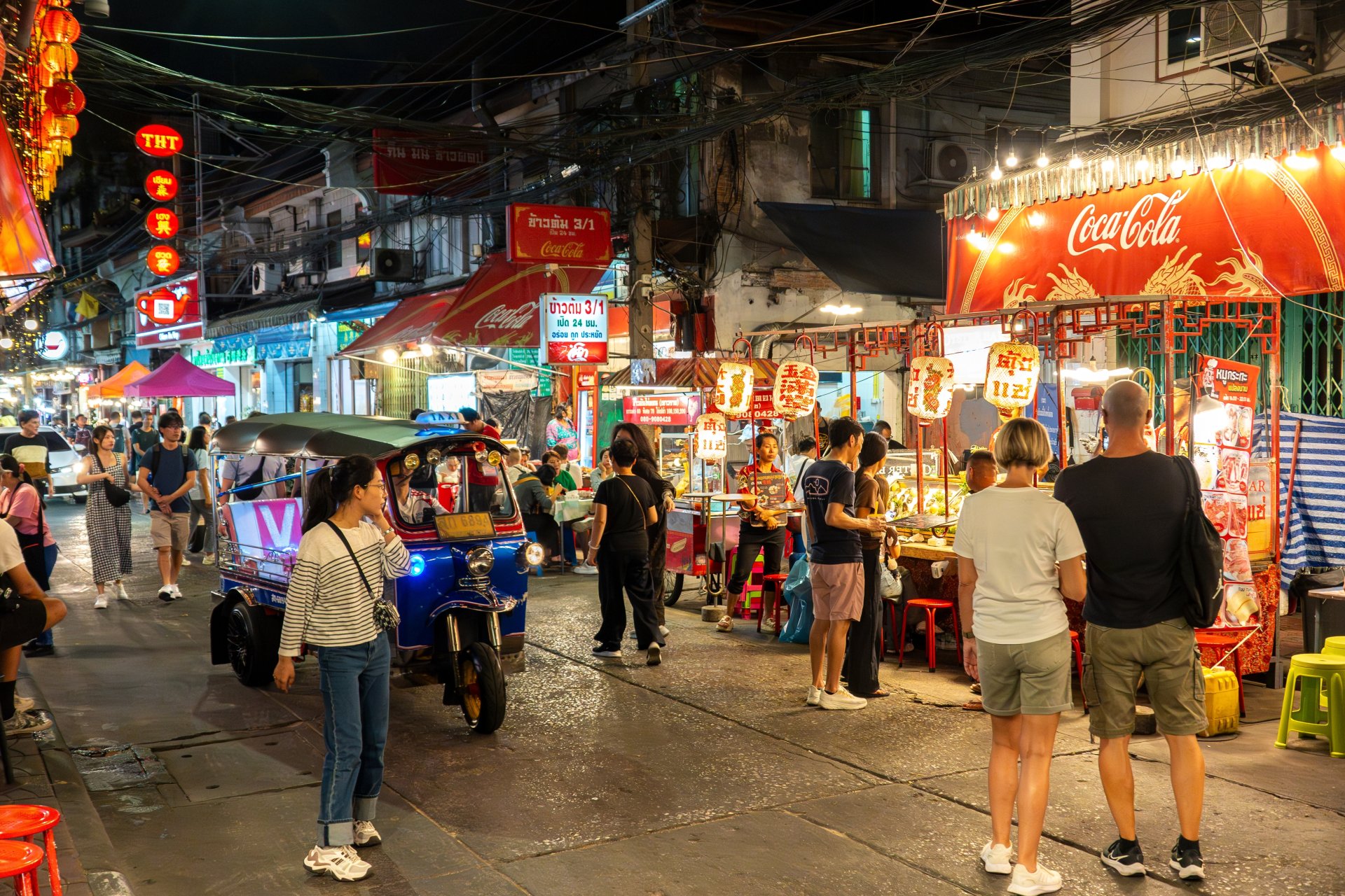 piata stradala aglomerata in bangkok noaptea cu standuri de mancare si lumini colorate