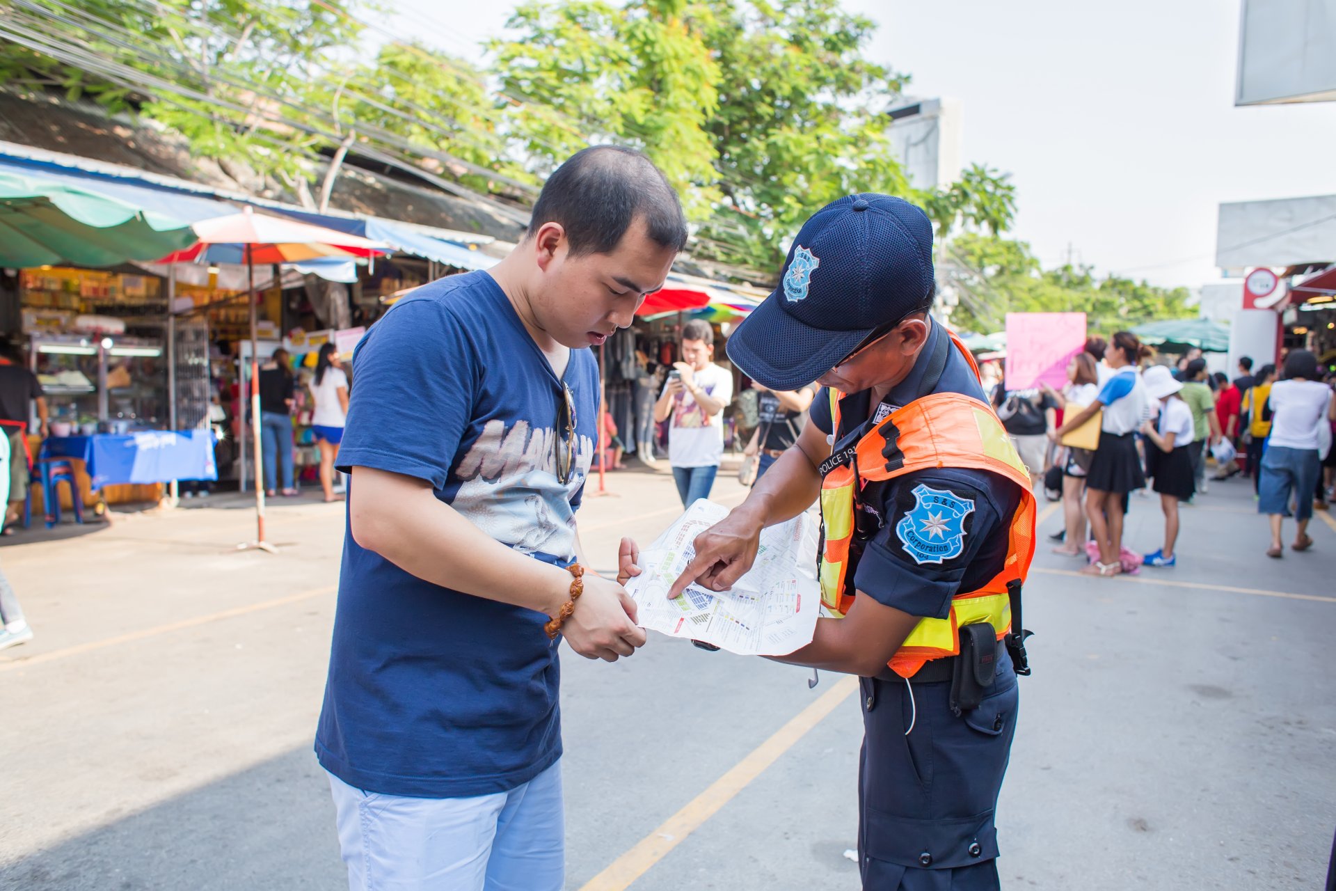 ofiter ofera informatii unui turist in piata jatujak bangkok thailanda