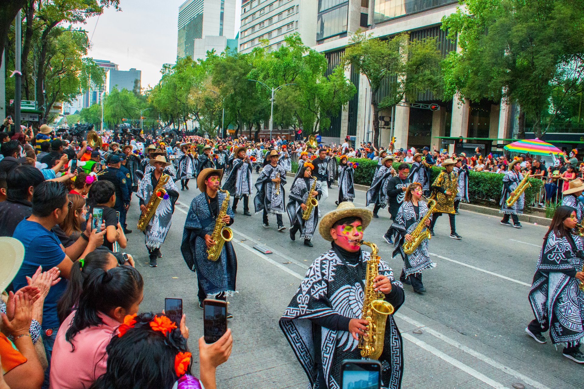 Parada de Día de los Muertos în Ciudad de Mexico, cu participanți în costume colorate, machiaje tradiționale și decorațiuni festive care celebrează memoria strămoșilor
