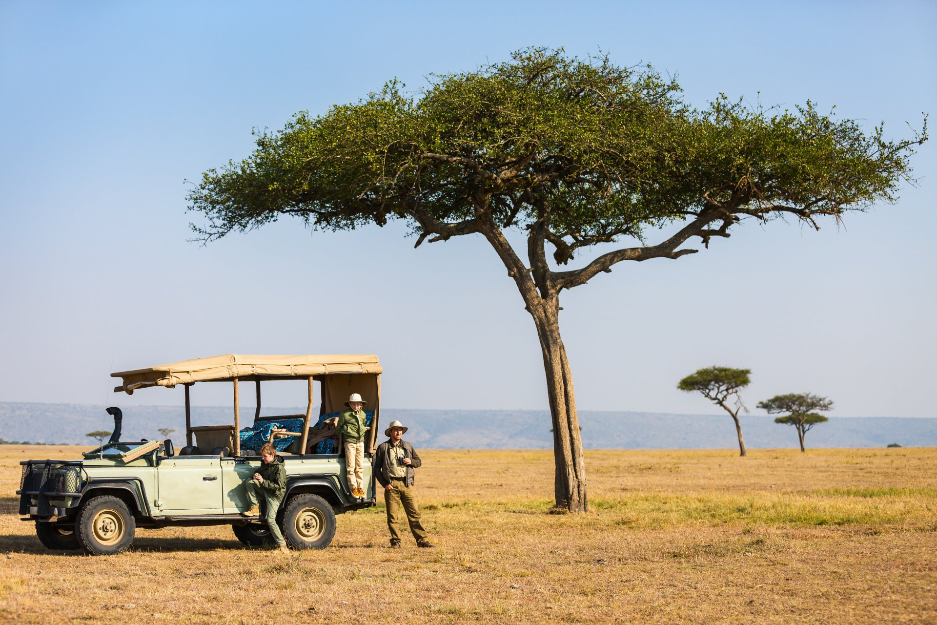 familie tata si copii in safari african in timpul unui game drive de dimineata in Parcul National Serengeti