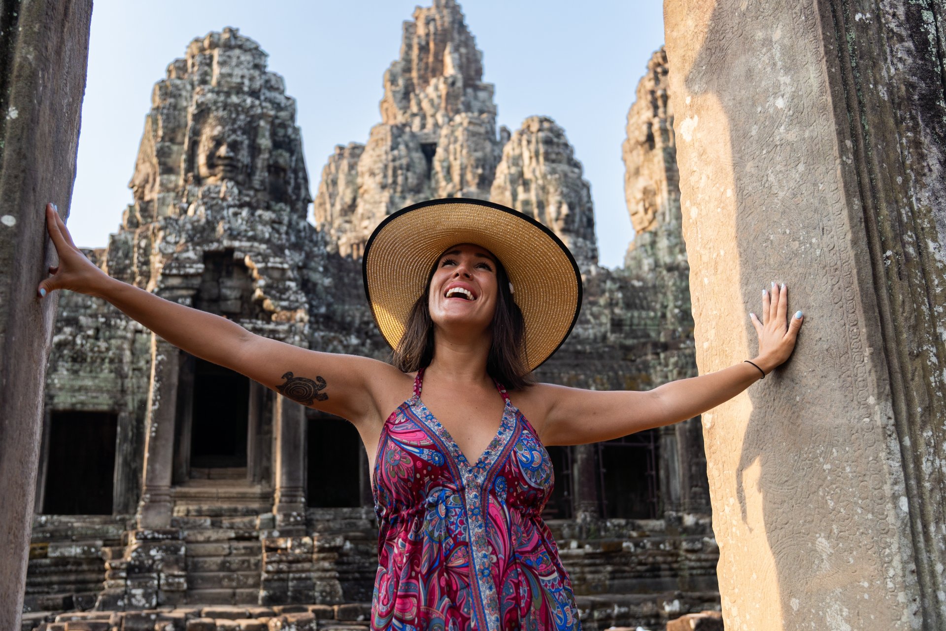 femeie bucurandu-se printre ruinele templului antic din cambodgia