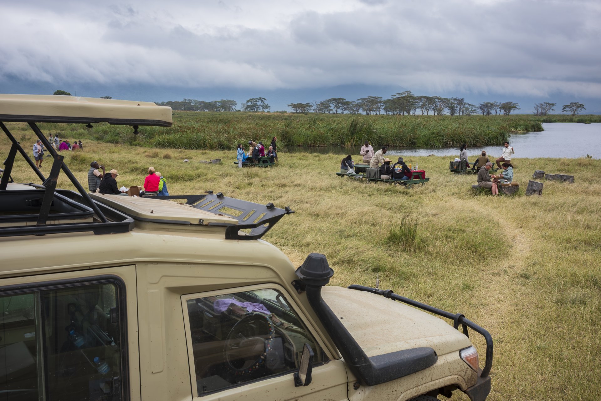 turiști safari și ghizi iau pauză de prânz lângă un lac în craterul ngorongoro tanzania zi înnorată
