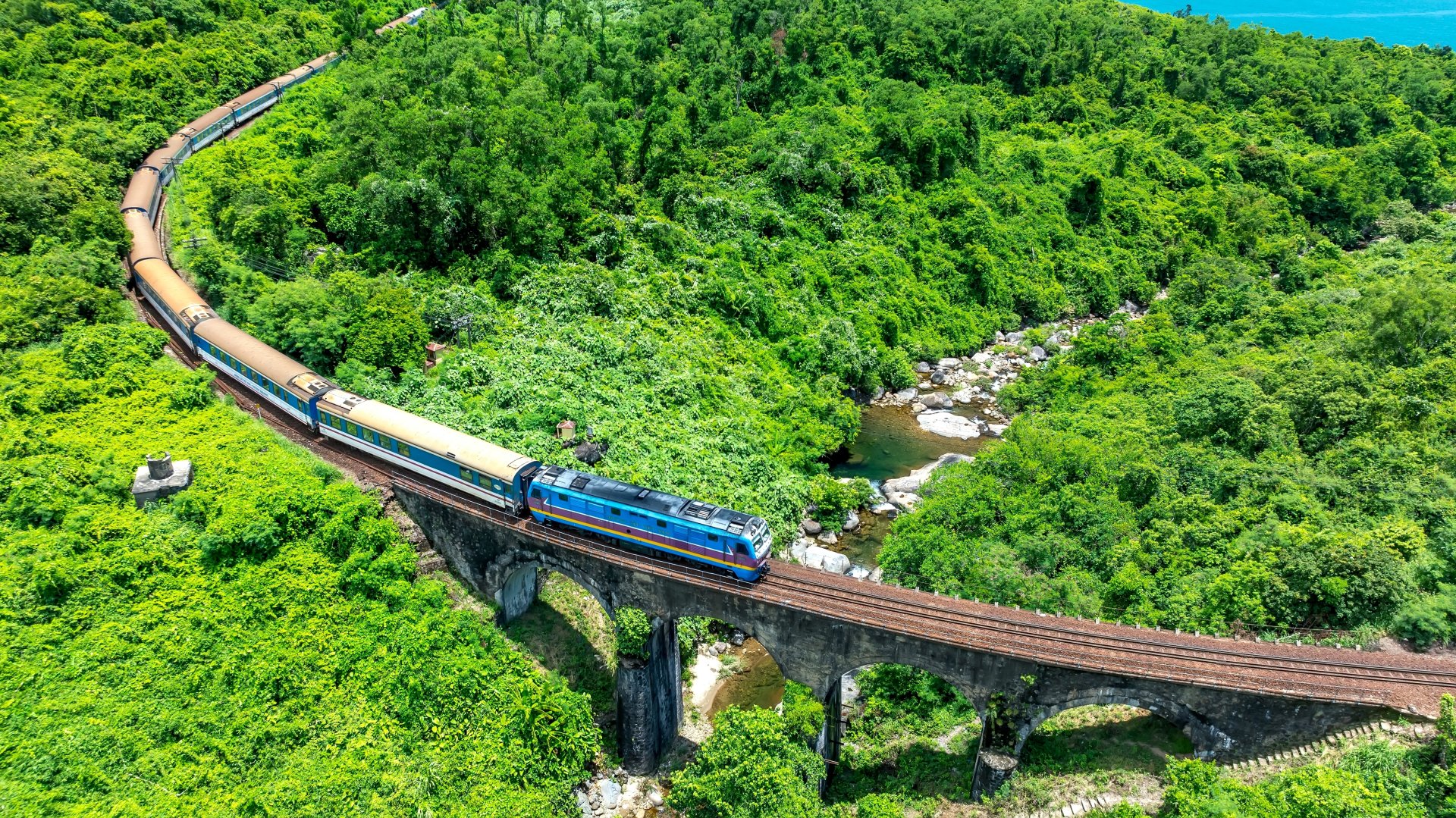 Tren care trece prin padurea tropicala de pe Hai Van Pass in Hue, Vietnam, cu vedere catre tarm