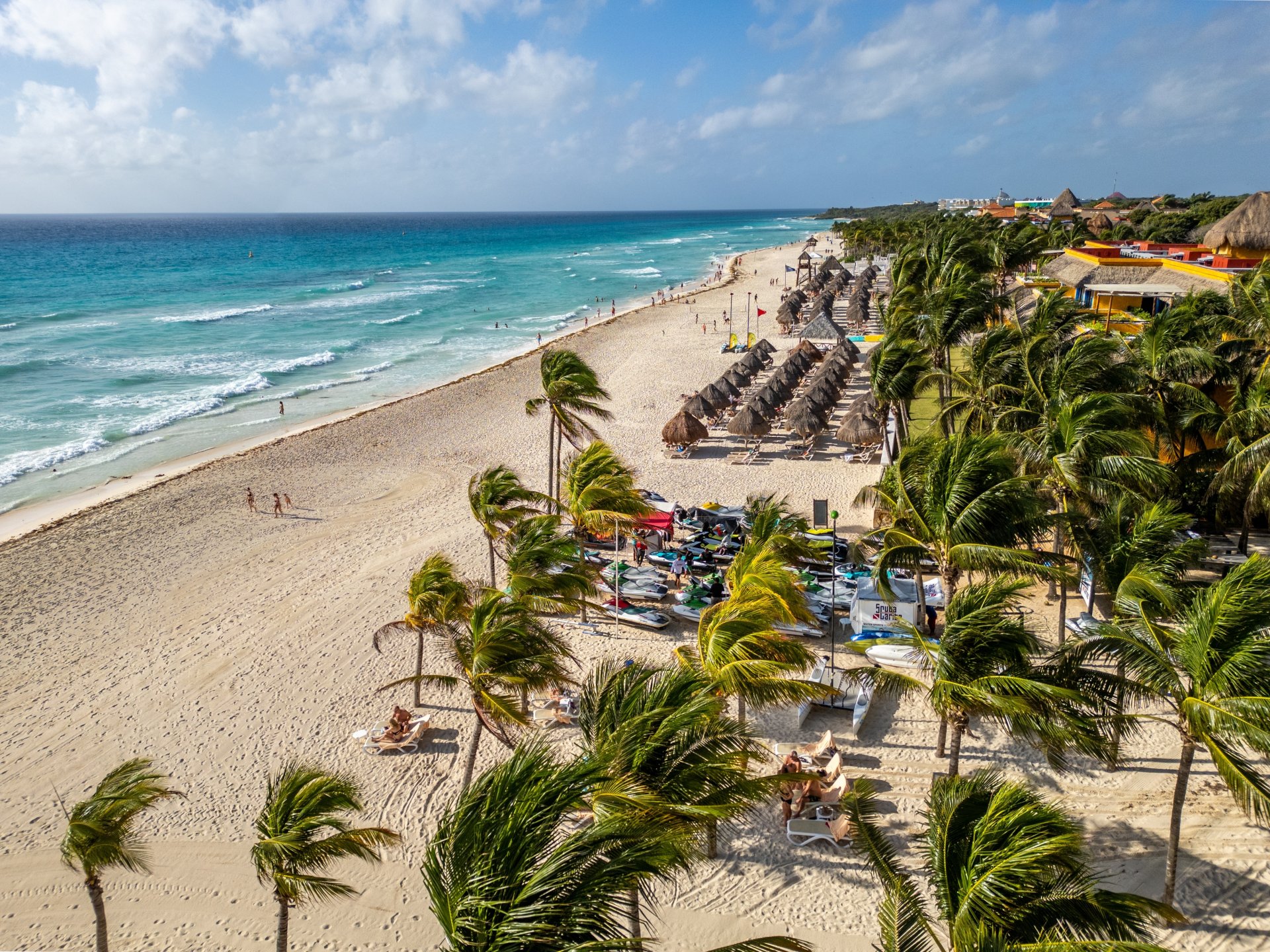 nisip alb din Playa del Carmen, văzută de sus, cu palmieri și turiști relaxându-se